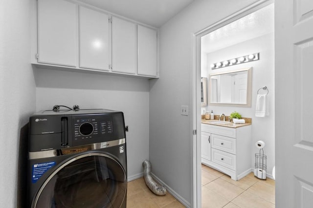 laundry area featuring cabinets, light tile patterned flooring, washer / dryer, and sink