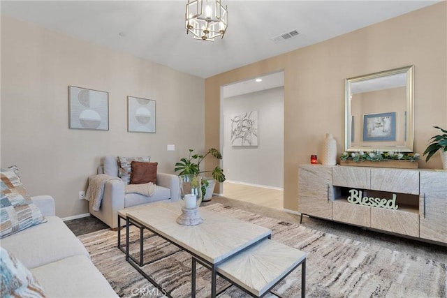 living room featuring a notable chandelier and light hardwood / wood-style flooring