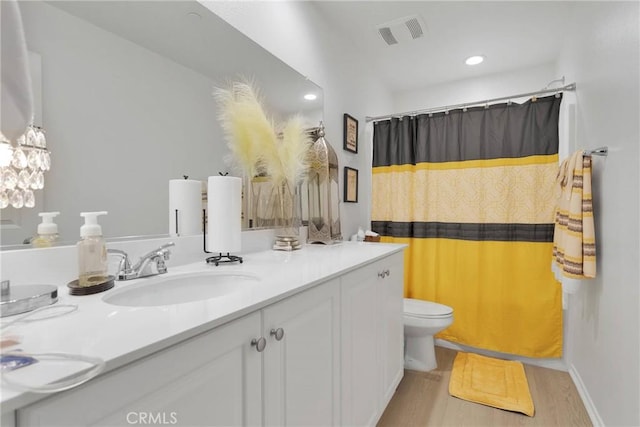 bathroom featuring wood-type flooring, toilet, and vanity