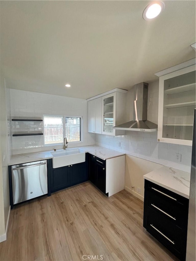 kitchen with sink, light hardwood / wood-style flooring, dishwasher, white cabinetry, and wall chimney exhaust hood