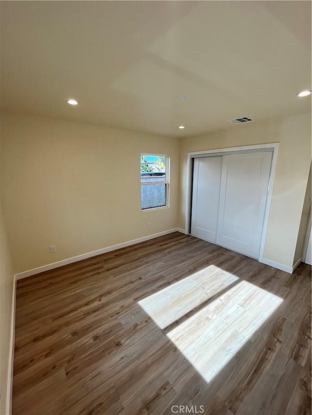 unfurnished bedroom featuring wood-type flooring and a closet