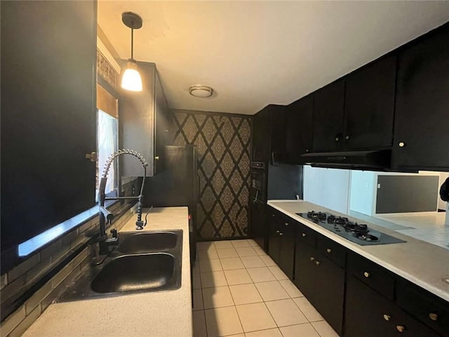 kitchen featuring decorative light fixtures, black appliances, sink, and light tile patterned floors