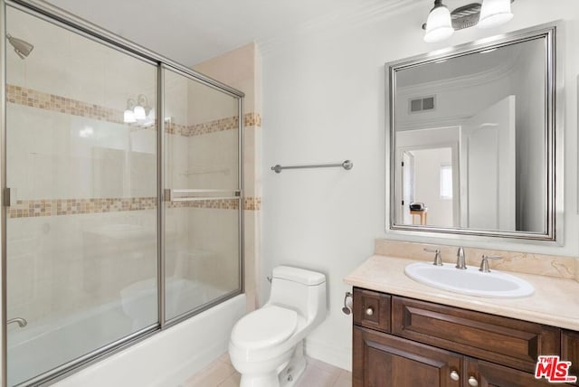 full bathroom featuring shower / bath combination with glass door, tile patterned floors, vanity, toilet, and ornamental molding