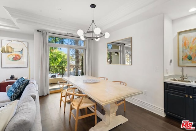 dining area featuring sink, dark hardwood / wood-style flooring, crown molding, and a chandelier