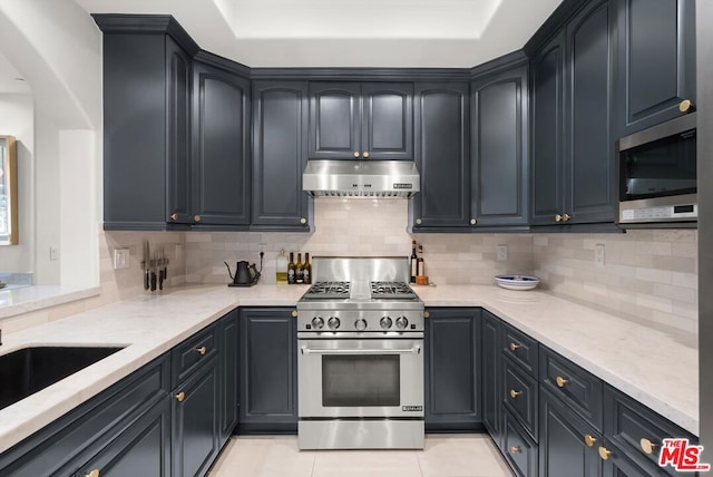 kitchen with backsplash, appliances with stainless steel finishes, extractor fan, and light tile patterned flooring