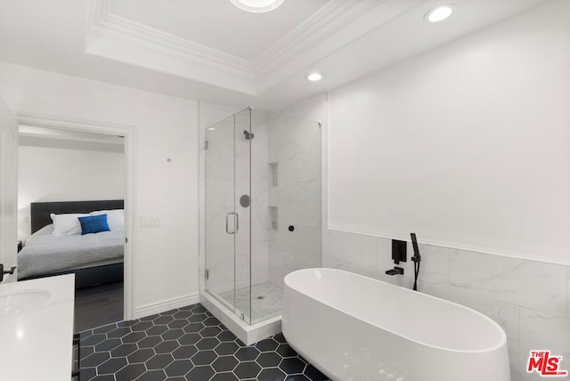 bathroom with tile walls, a raised ceiling, crown molding, and independent shower and bath