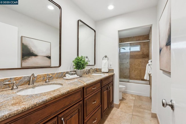 full bathroom featuring vanity, toilet, combined bath / shower with glass door, and tile patterned floors