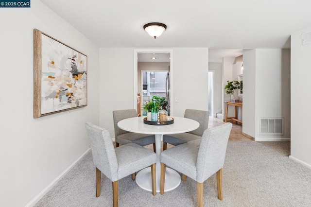 dining area with light colored carpet