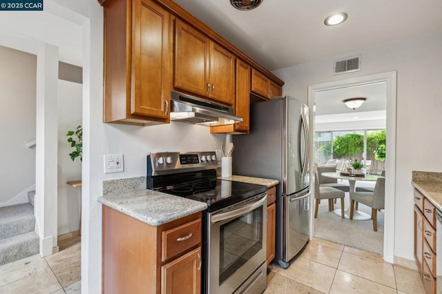 kitchen with stainless steel electric stove, light stone countertops, and light tile patterned flooring