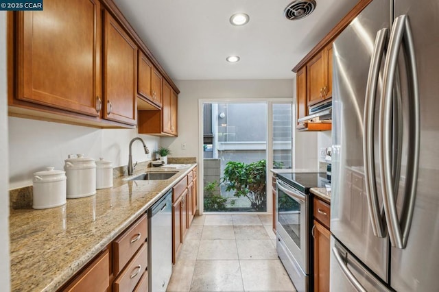 kitchen with appliances with stainless steel finishes, sink, ventilation hood, light tile patterned flooring, and light stone counters