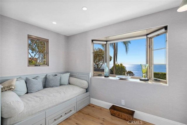 sitting room featuring a water view and light hardwood / wood-style flooring