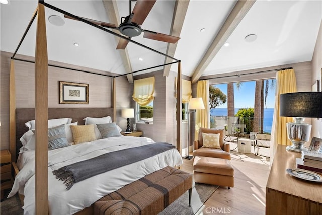 bedroom featuring ceiling fan, a water view, light hardwood / wood-style floors, and multiple windows