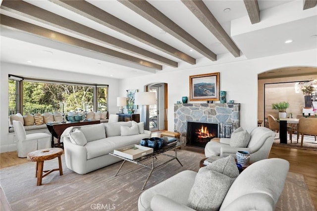 living room featuring beam ceiling, a fireplace, and hardwood / wood-style floors