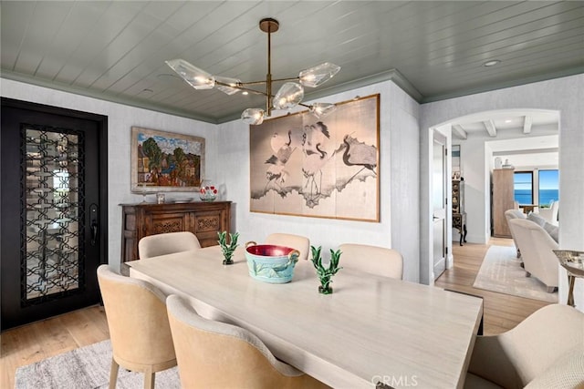 dining room featuring a notable chandelier, a water view, wood ceiling, and light hardwood / wood-style flooring