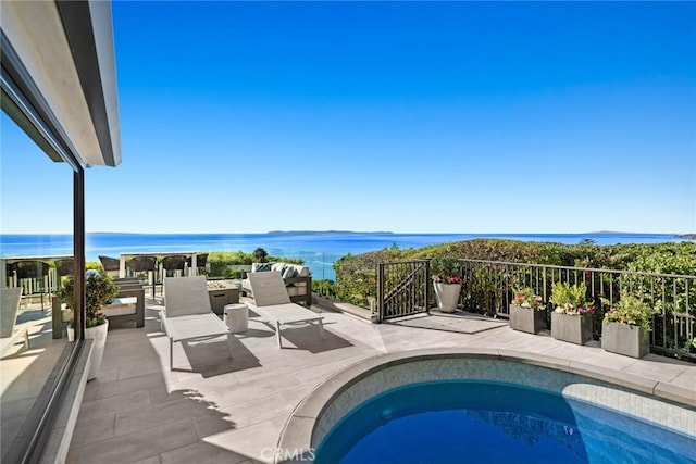 view of pool with a patio area and a water view