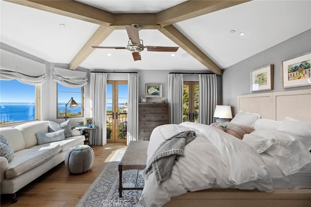 bedroom featuring ceiling fan, access to outside, light wood-type flooring, lofted ceiling with beams, and a water view