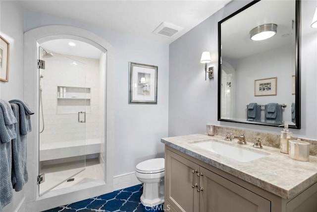 bathroom featuring vanity, toilet, and walk in shower