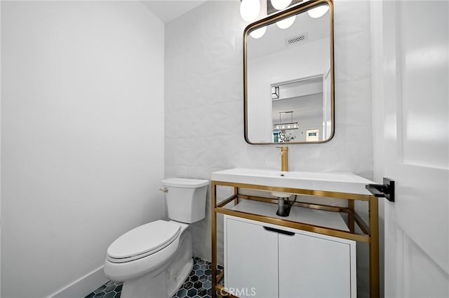 bathroom featuring sink, toilet, and tile patterned flooring