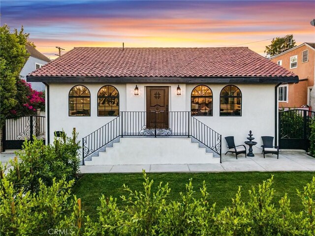 view of front of home featuring a patio and a lawn