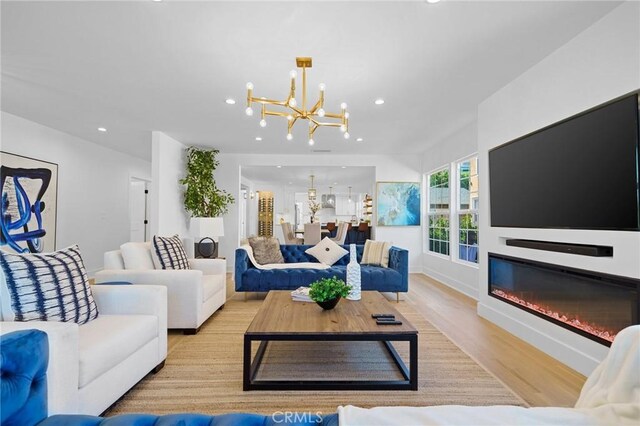 living room with a chandelier and light hardwood / wood-style flooring