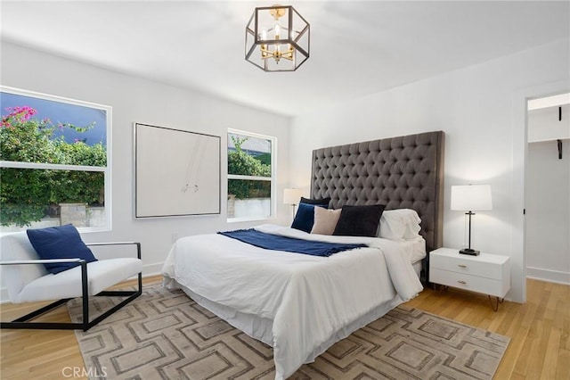 bedroom featuring light wood-type flooring and a chandelier