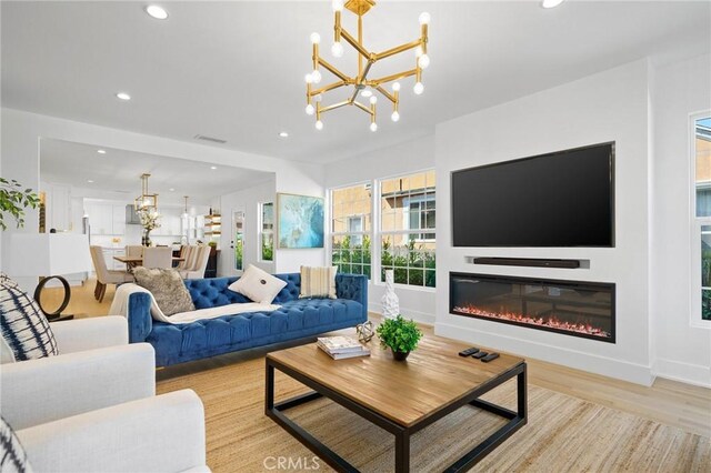 living room with light wood-type flooring and a notable chandelier