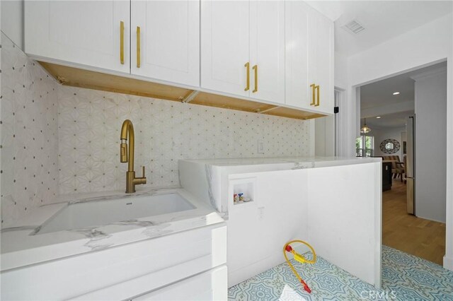 laundry area featuring sink, hookup for a washing machine, and cabinets