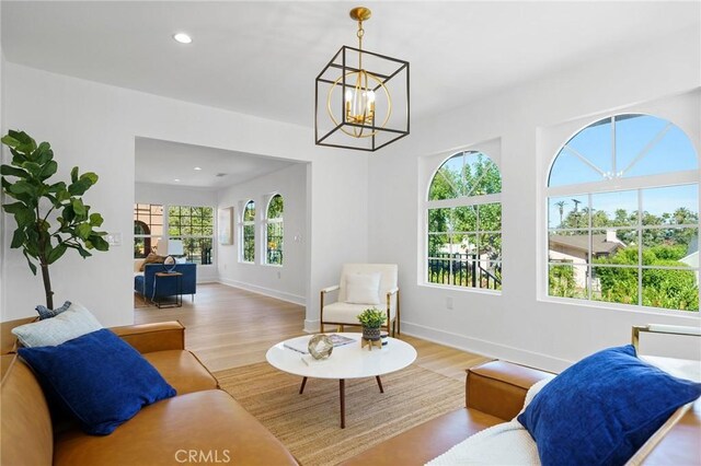 living room with light wood-type flooring and a notable chandelier