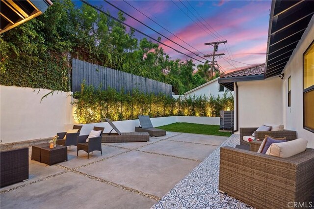 patio terrace at dusk featuring central air condition unit and outdoor lounge area