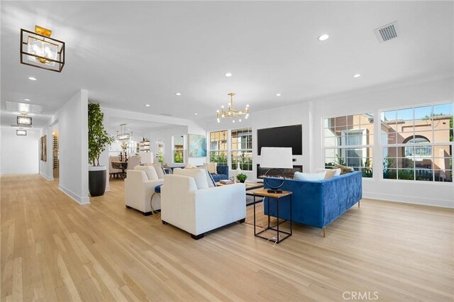 living room featuring a notable chandelier and light wood-type flooring