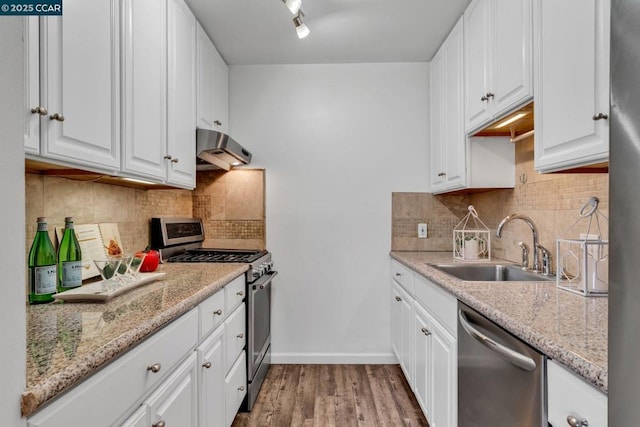 kitchen with sink, light stone counters, white cabinetry, and stainless steel appliances