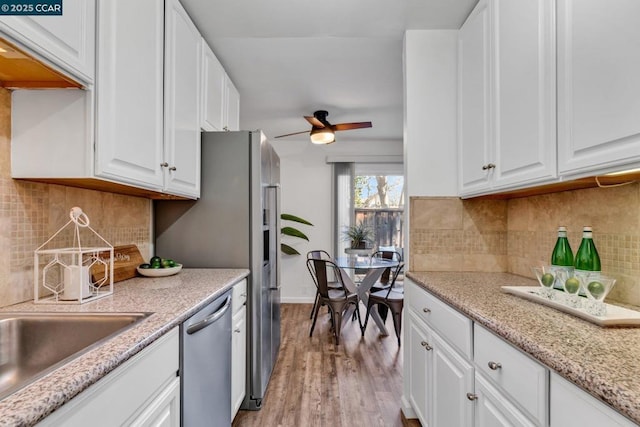 kitchen featuring light hardwood / wood-style floors, white cabinetry, dishwasher, and ceiling fan