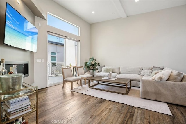 living room featuring a towering ceiling and hardwood / wood-style floors