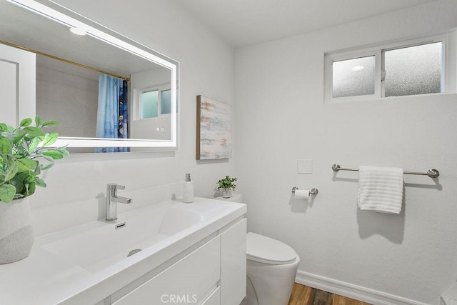 bathroom featuring vanity, hardwood / wood-style floors, and toilet