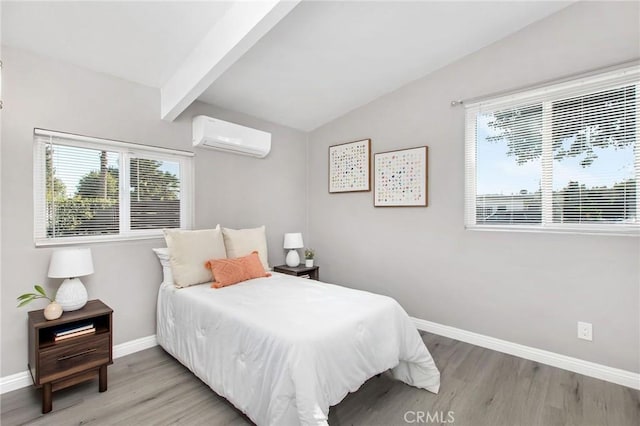 bedroom featuring vaulted ceiling with beams, light hardwood / wood-style floors, and a wall unit AC