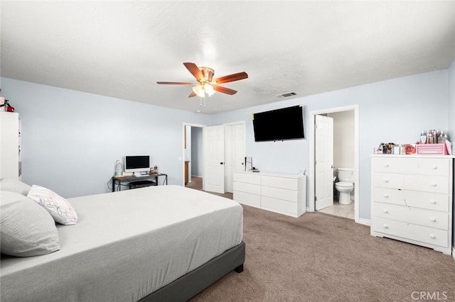 carpeted bedroom with ceiling fan and ensuite bath