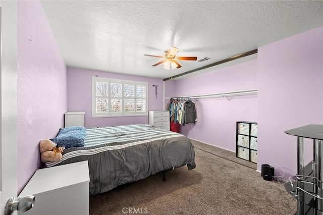 bedroom with carpet flooring, a textured ceiling, ceiling fan, and a closet