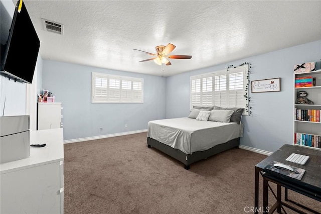 bedroom with ceiling fan, carpet flooring, and a textured ceiling