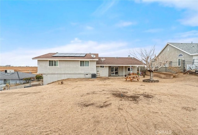 rear view of property with a patio and solar panels