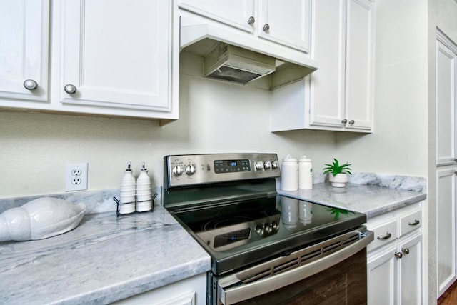 kitchen featuring white cabinetry, stainless steel electric stove, and light stone countertops