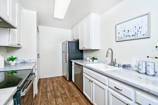 kitchen with sink, stainless steel appliances, dark hardwood / wood-style floors, light stone countertops, and white cabinets