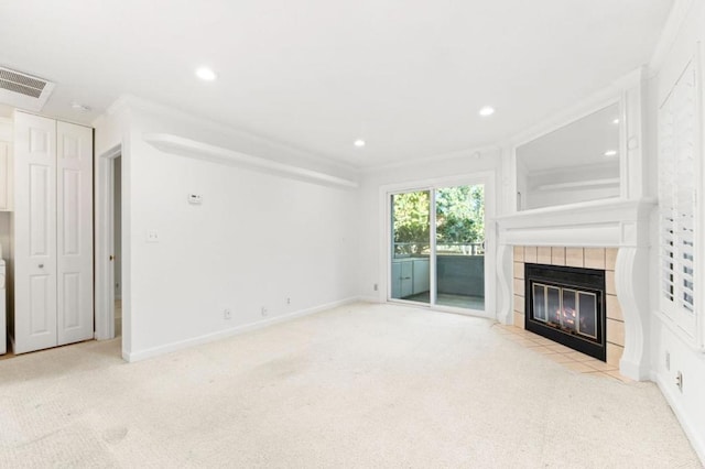 unfurnished living room with light carpet, ornamental molding, and a tile fireplace