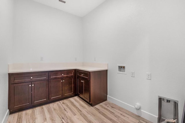 laundry room with cabinets, washer hookup, and light hardwood / wood-style flooring