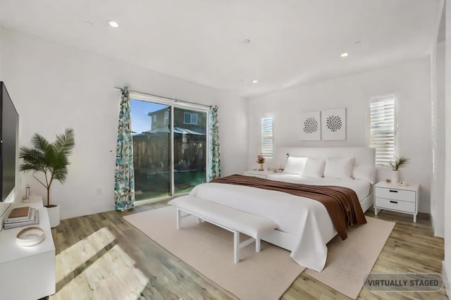 bedroom with multiple windows, light hardwood / wood-style flooring, and access to outside