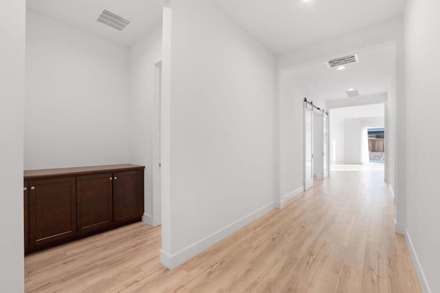 hall featuring a barn door and light wood-type flooring