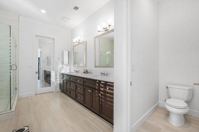 bathroom featuring toilet, vanity, tile patterned floors, and a shower with shower door