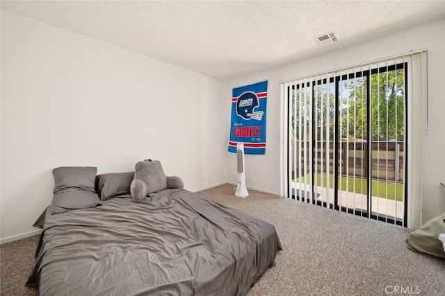 carpeted bedroom featuring access to exterior and a textured ceiling