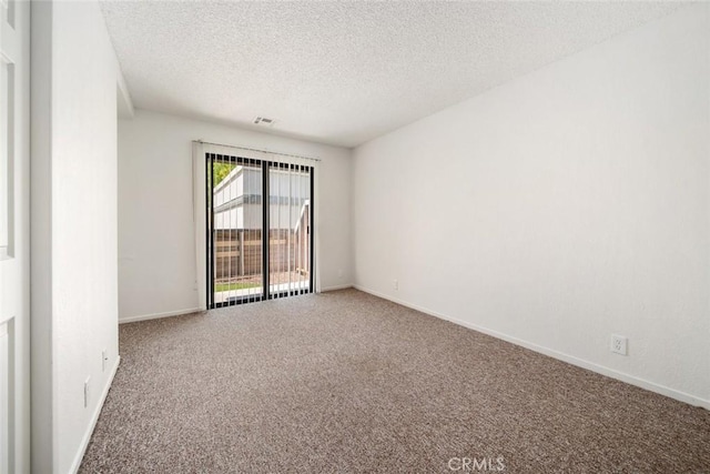 carpeted empty room featuring a textured ceiling