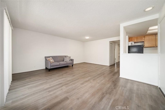 unfurnished room featuring hardwood / wood-style floors and a textured ceiling