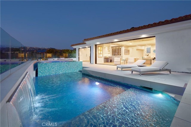 view of swimming pool with a jacuzzi, a patio, and pool water feature